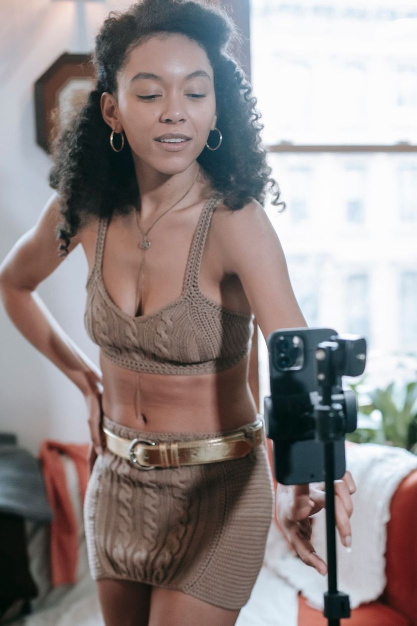 Creator recording an outfit video on a smartphone