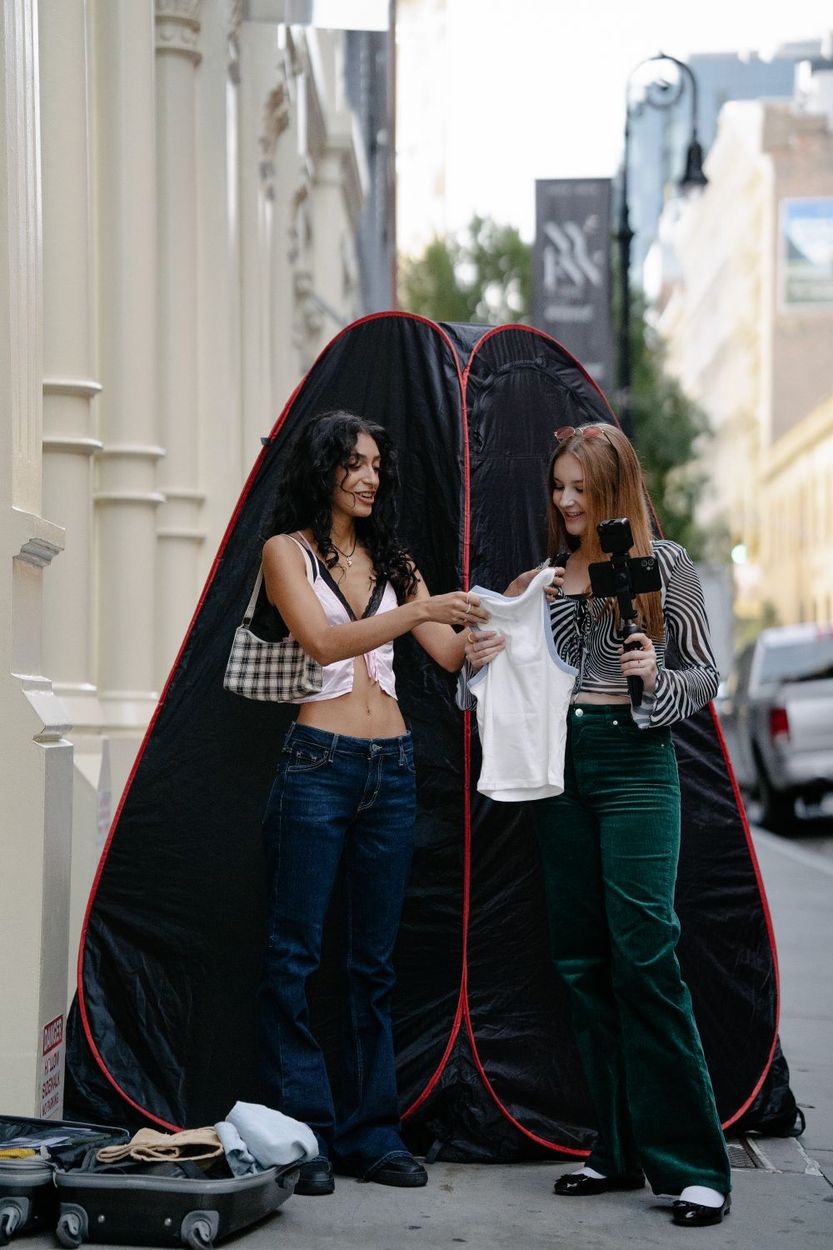 Two creators filming an outfit video on a city street