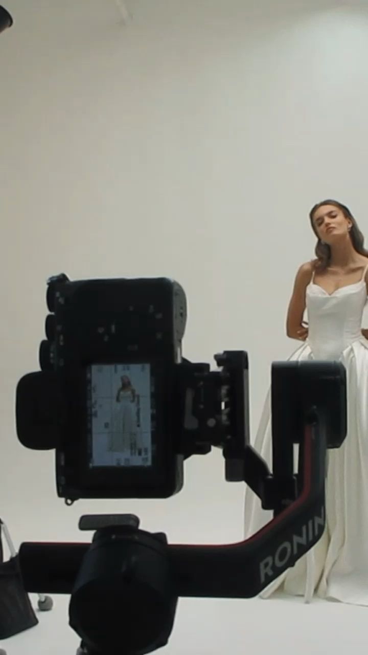 Video camera on a gimbal filming the model on the white cyclorama