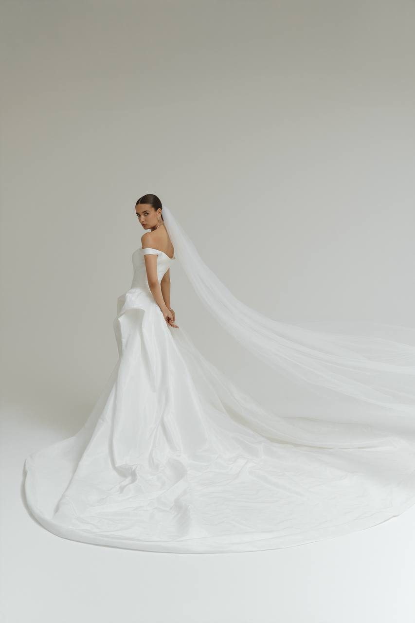 Oui The Label bridal gown with a long train and veil in a New York studio