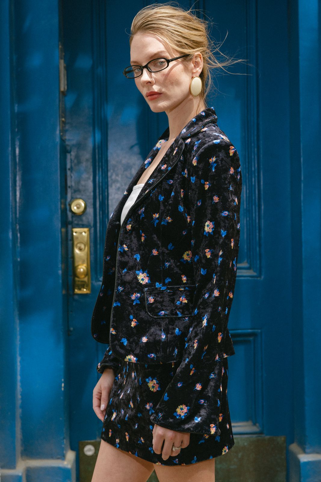 Model in an Anka Studios floral blazer against a blue New York door