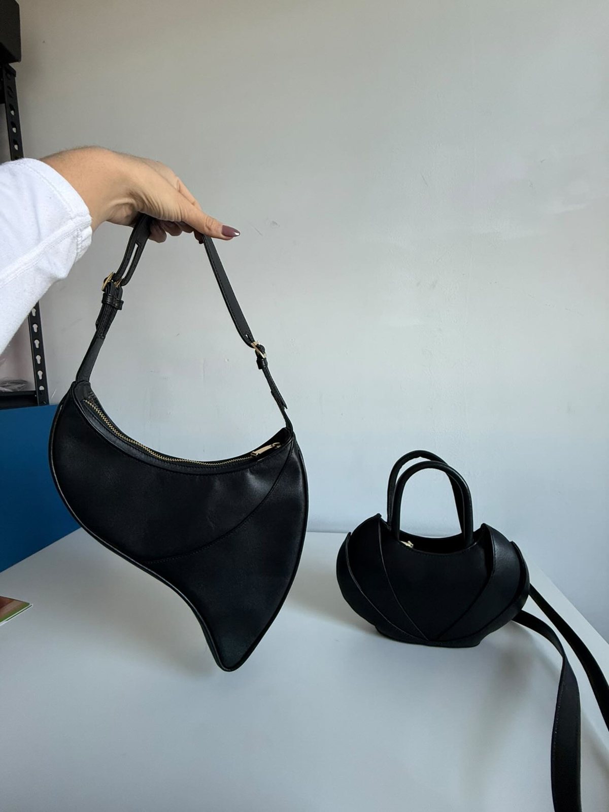 The Made in Neptune crescent shoulder bag and sculpted top-handle bag side by side
