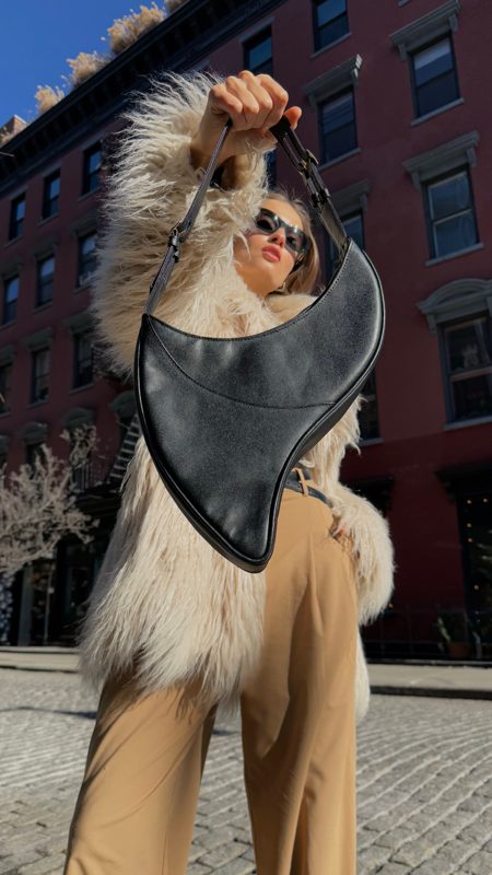 Our look: cream faux-fur coat, camel trousers and the crescent bag raised over the shoulder