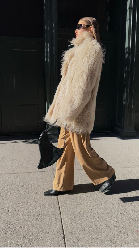 Street style walk in a cream coat and camel trousers