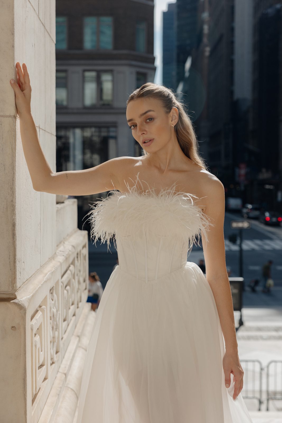 Model in a feathered Sienricher gown against a Midtown building
